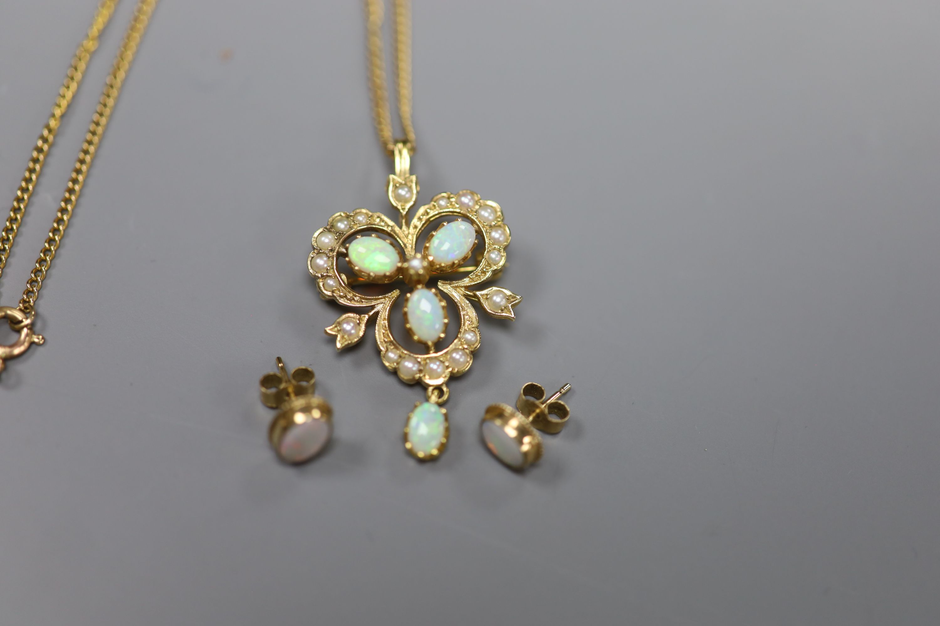 A modern 9ct gold, opal and seed pearl openwork drop pendant, on 9ct gold chain and a pair of opal 9ct stud earrings, gross 9.1g.